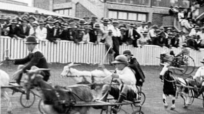 Black and white still from film of a horse race