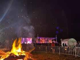 Bonfire in the foreground with the crowd dancing in the background to SA local band