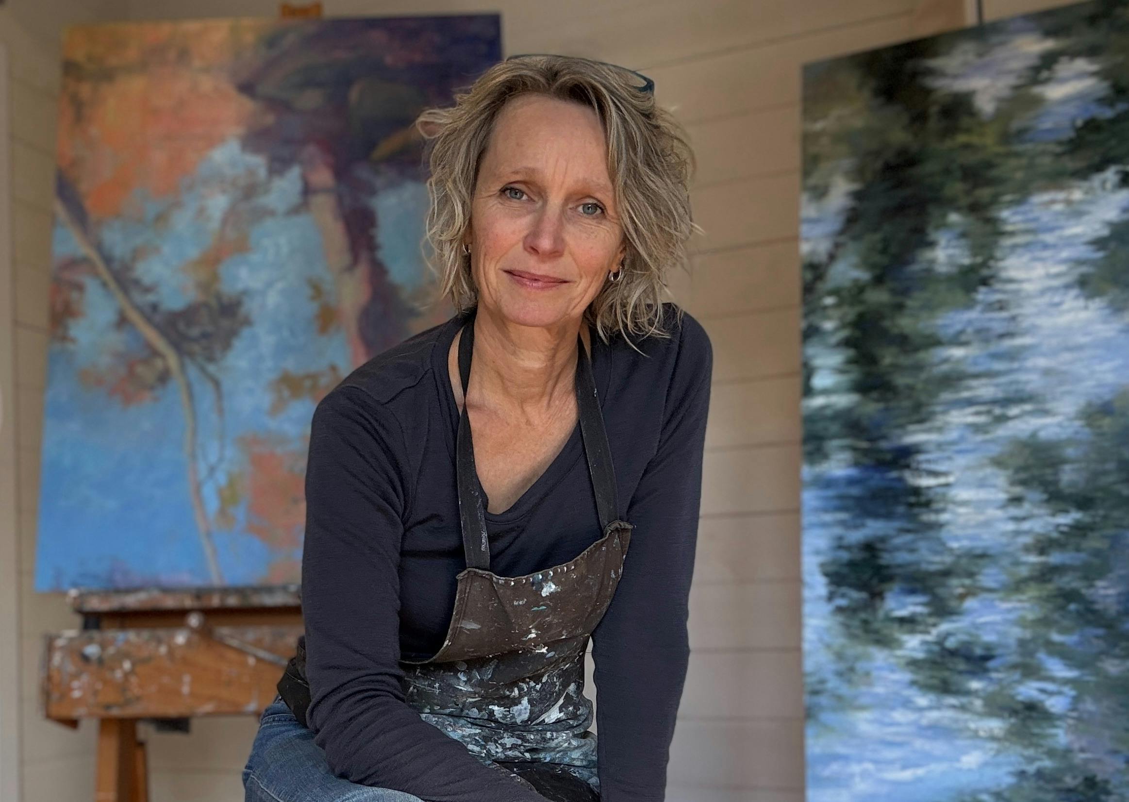 Artist in studio with paintings