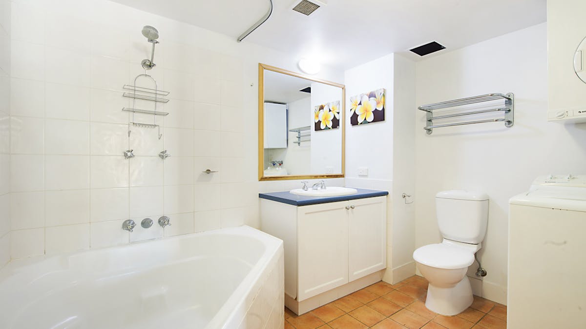 bathroom with shower over large corner bath