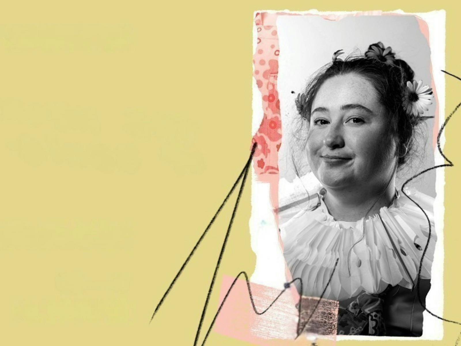 A young woman wearing a ruffle smiles at the camera, against an olive background