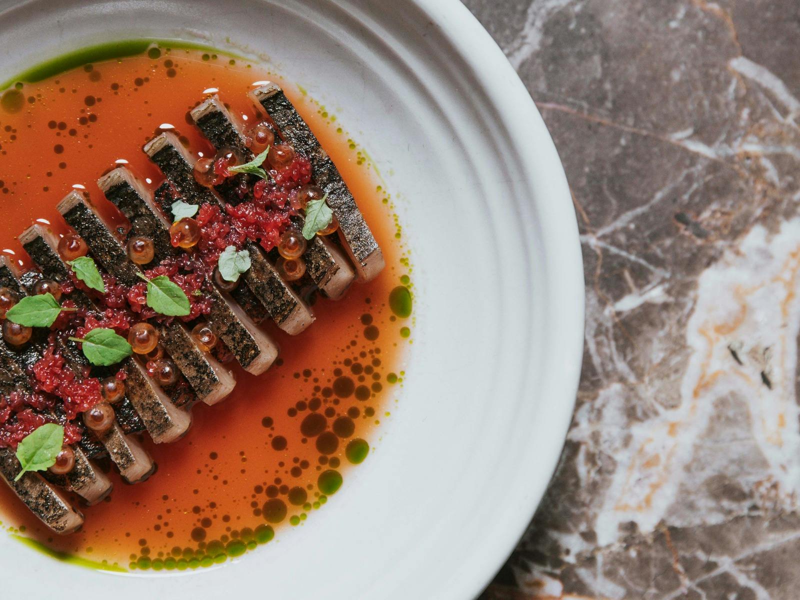 Cured fish with watermelon & dashi broth, finger lime and roe from the seasonal menu