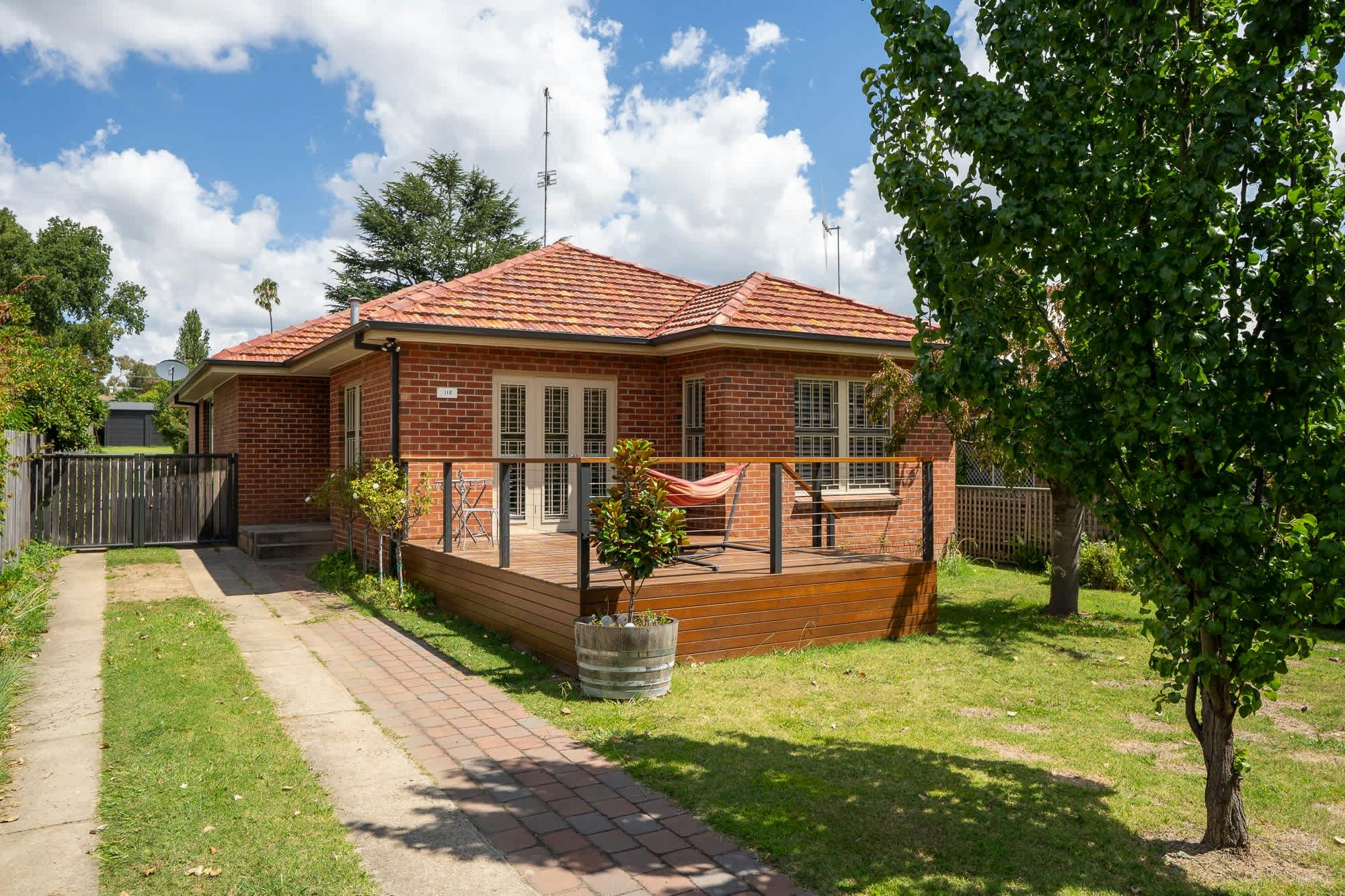 Sophisticated and neat front yard with a hammock to sit and soak up the sun.