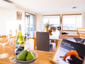 Open plan living upstairs with large dining table and amazing sea views