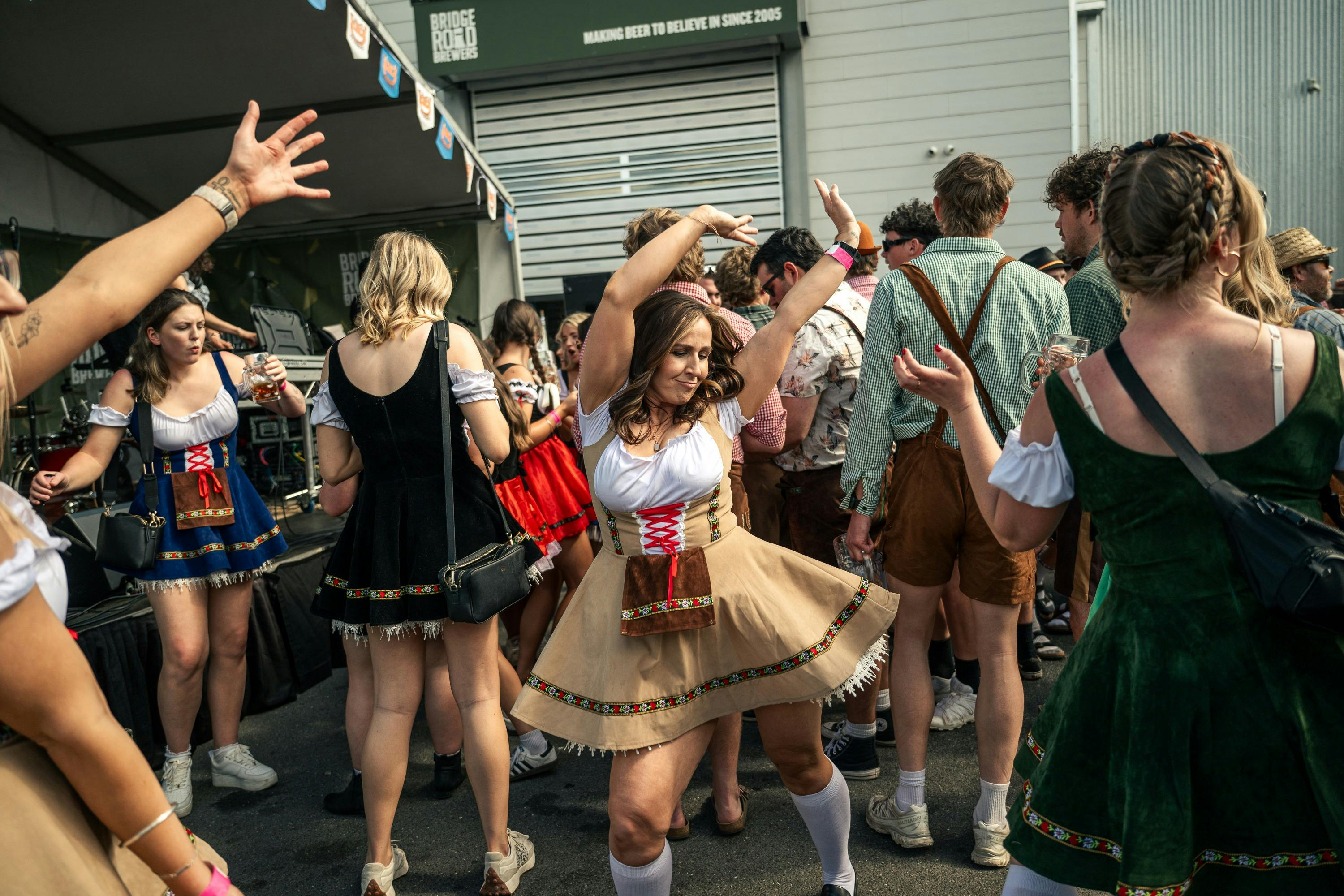 Young woman dancing among the crowd of people.