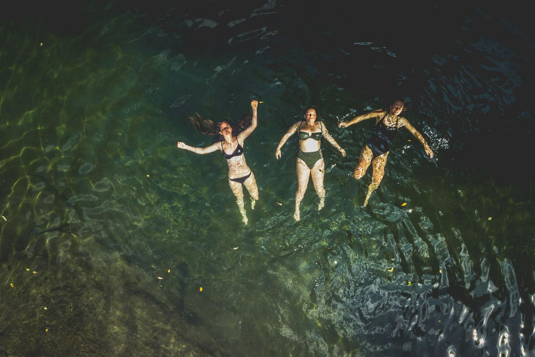 Three girls float in a the water of the Allyn River at Ladies Well.