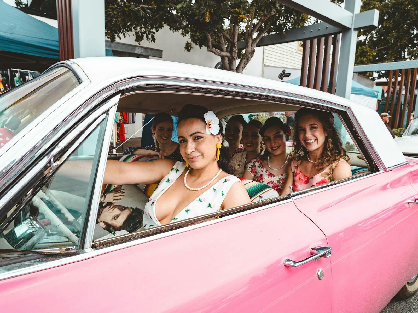 Pin Ups sitting in a pink Cadillac