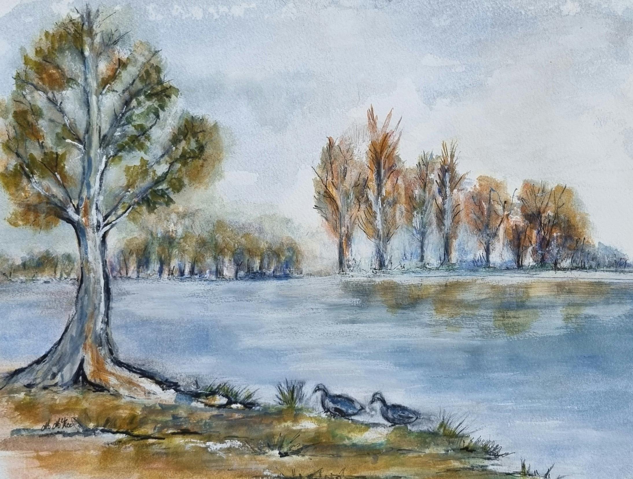 A reflected lake view with blue water and  line of trees under a cloudy sky