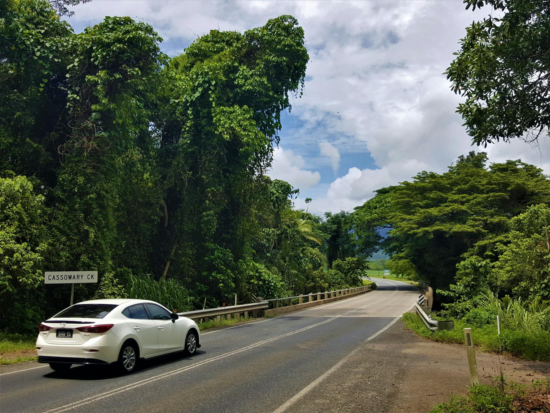A view of a white car about to cross Cassowary Creek near the town of Mossman.