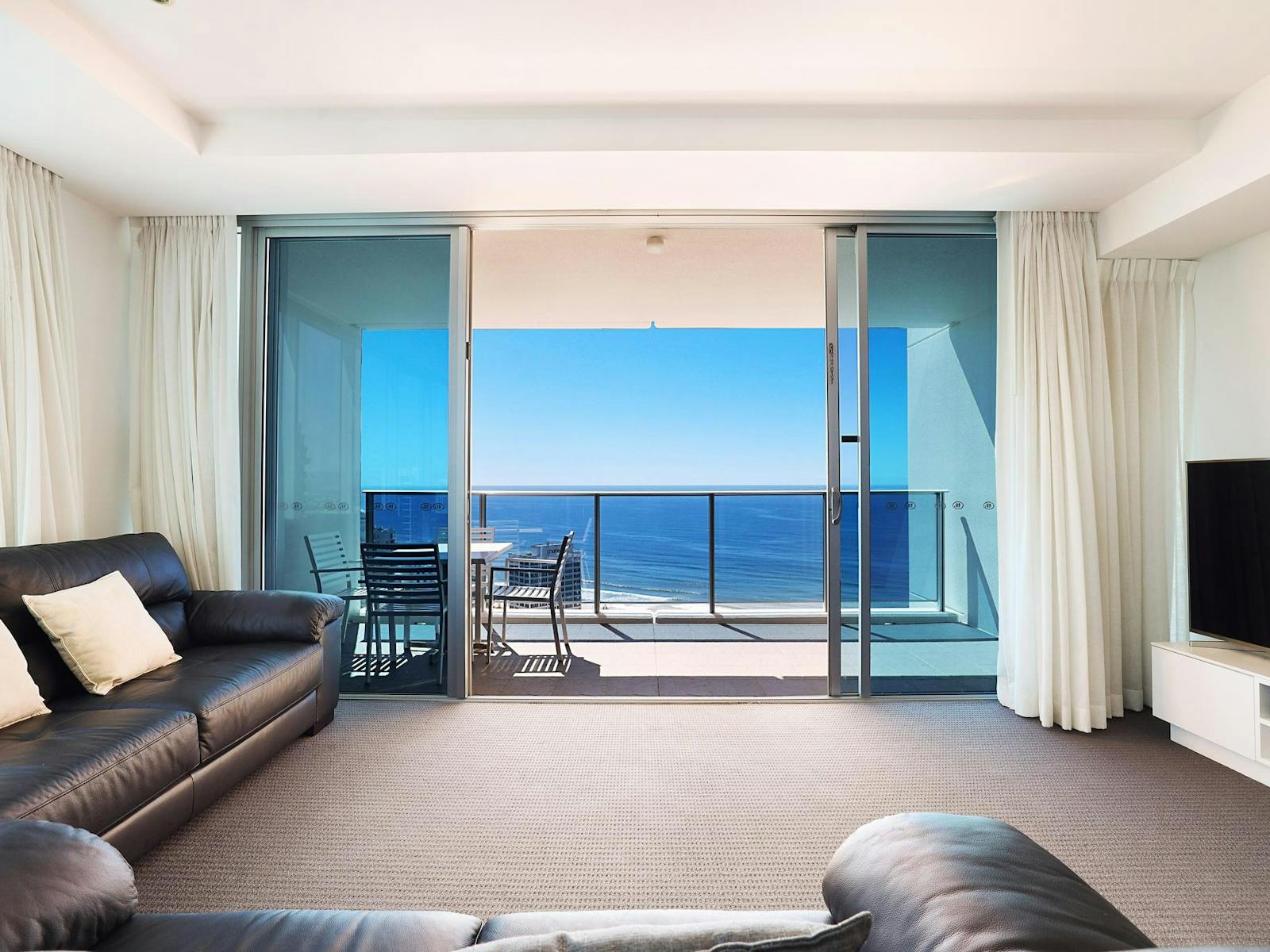 Lounge room with TV, balcony with ocean views - level 28 Hilton Residences Surfers Paradise Lounge room with TV, balcony with ocean views - level 28 Hilton Residences Surfers Paradise