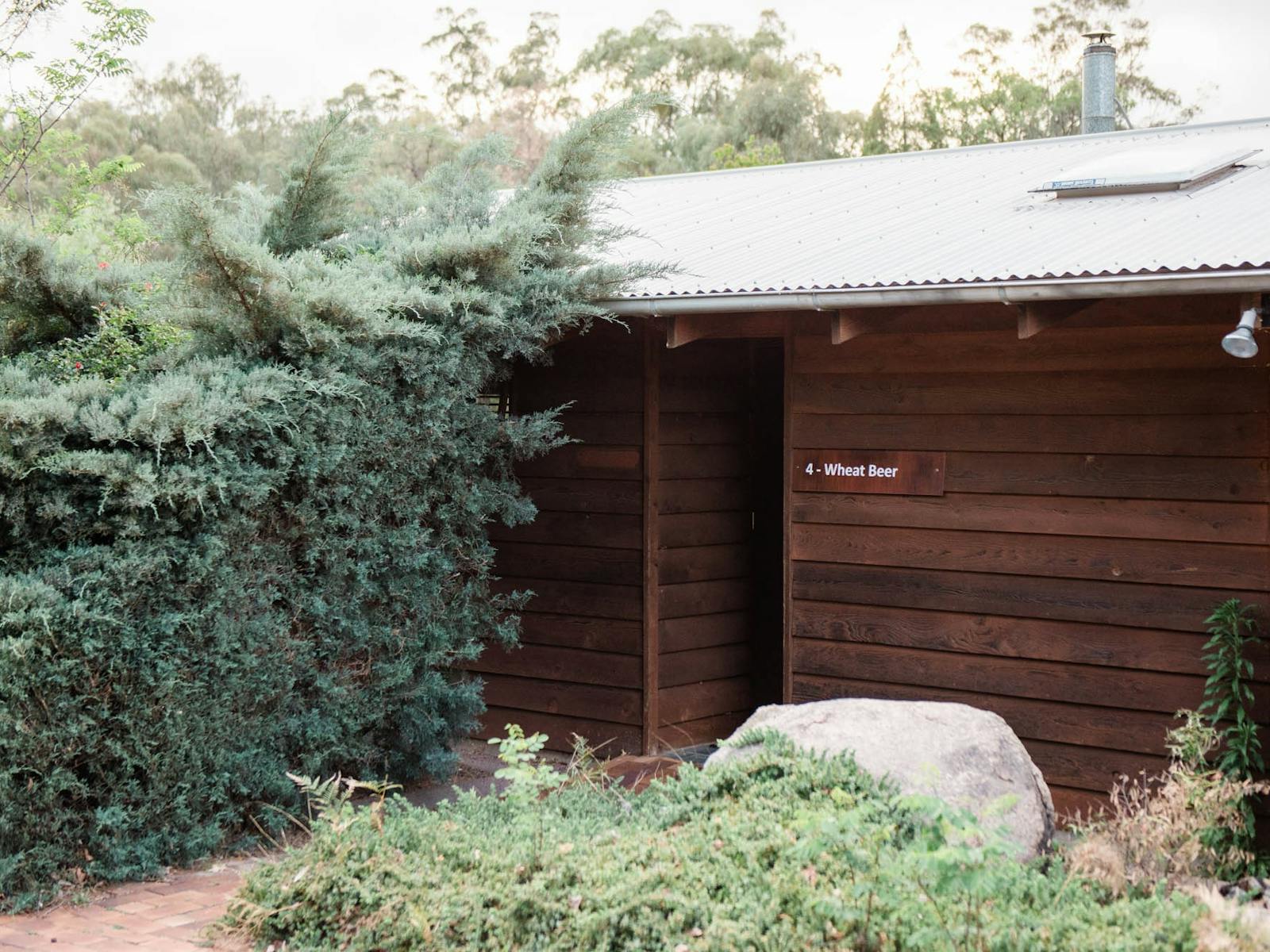 Timber suite building exterior with large hedge Timber suite building exterior with large hedge