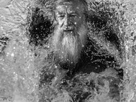 Black and white photo of bearded man in ocean