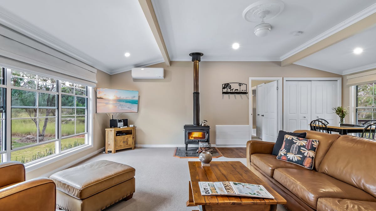 Coolibah Cottage living area including fireplace, leather lounges, overlooking garden