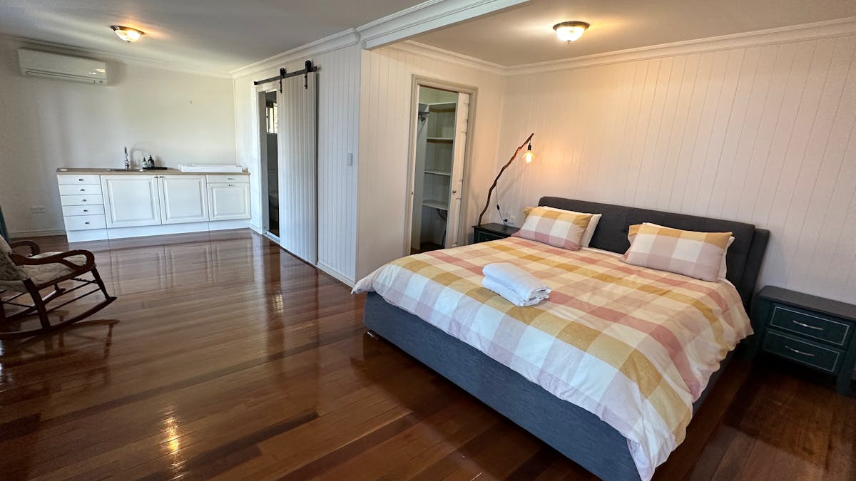 Bedroom with king bed with ocean and city views. Bedroom has ensuite and wardrobe