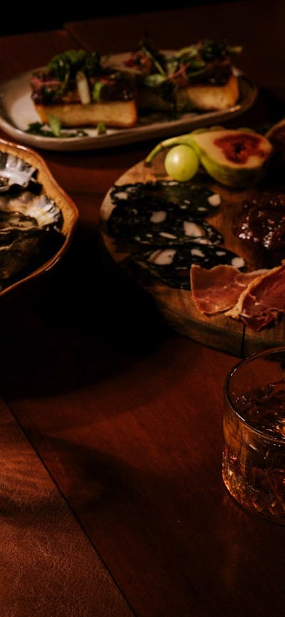Dining table with fresh oysters, sliced steak and wine glasses