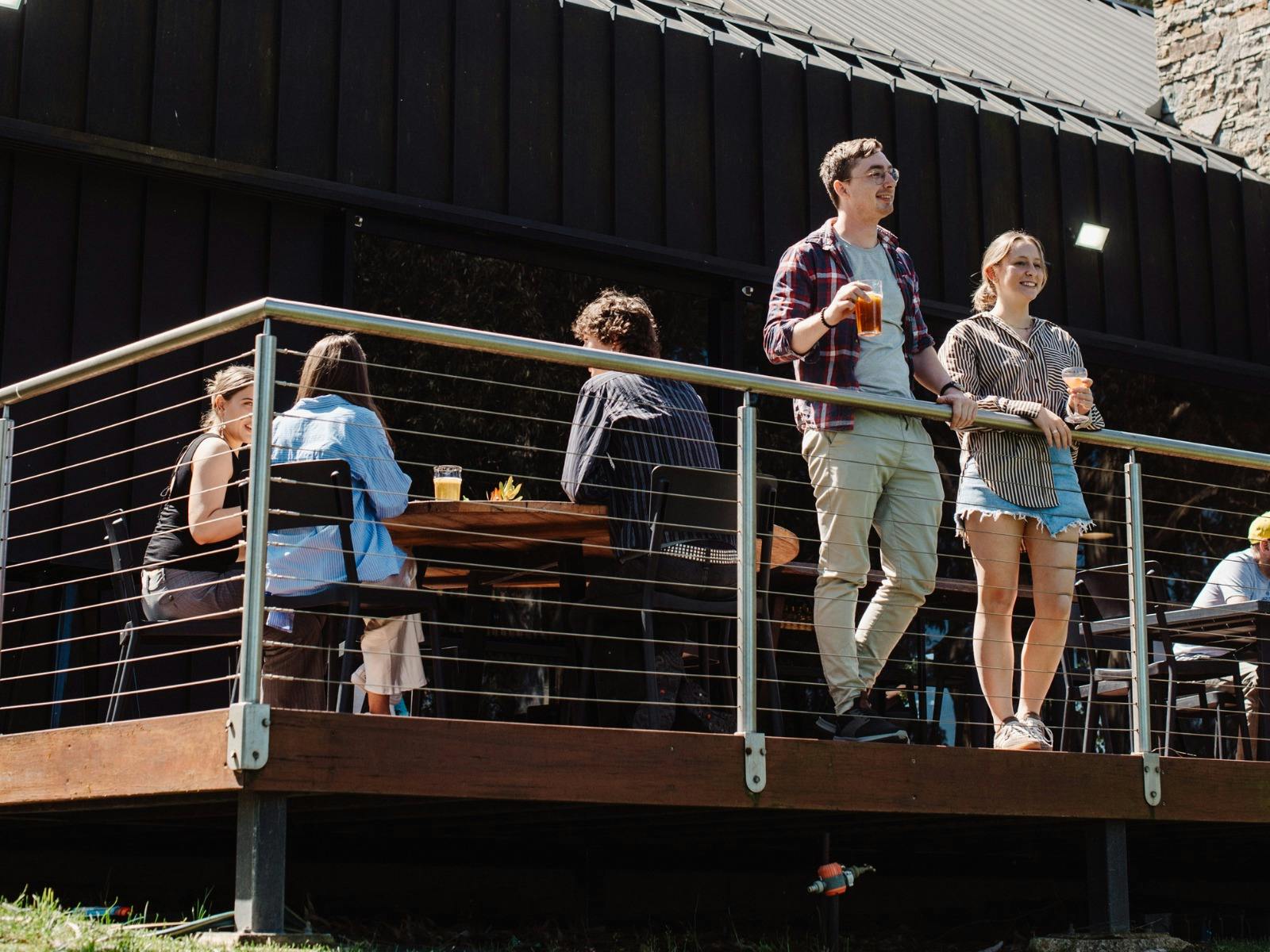 LOT.100 Balcony with people casually dining/drinking