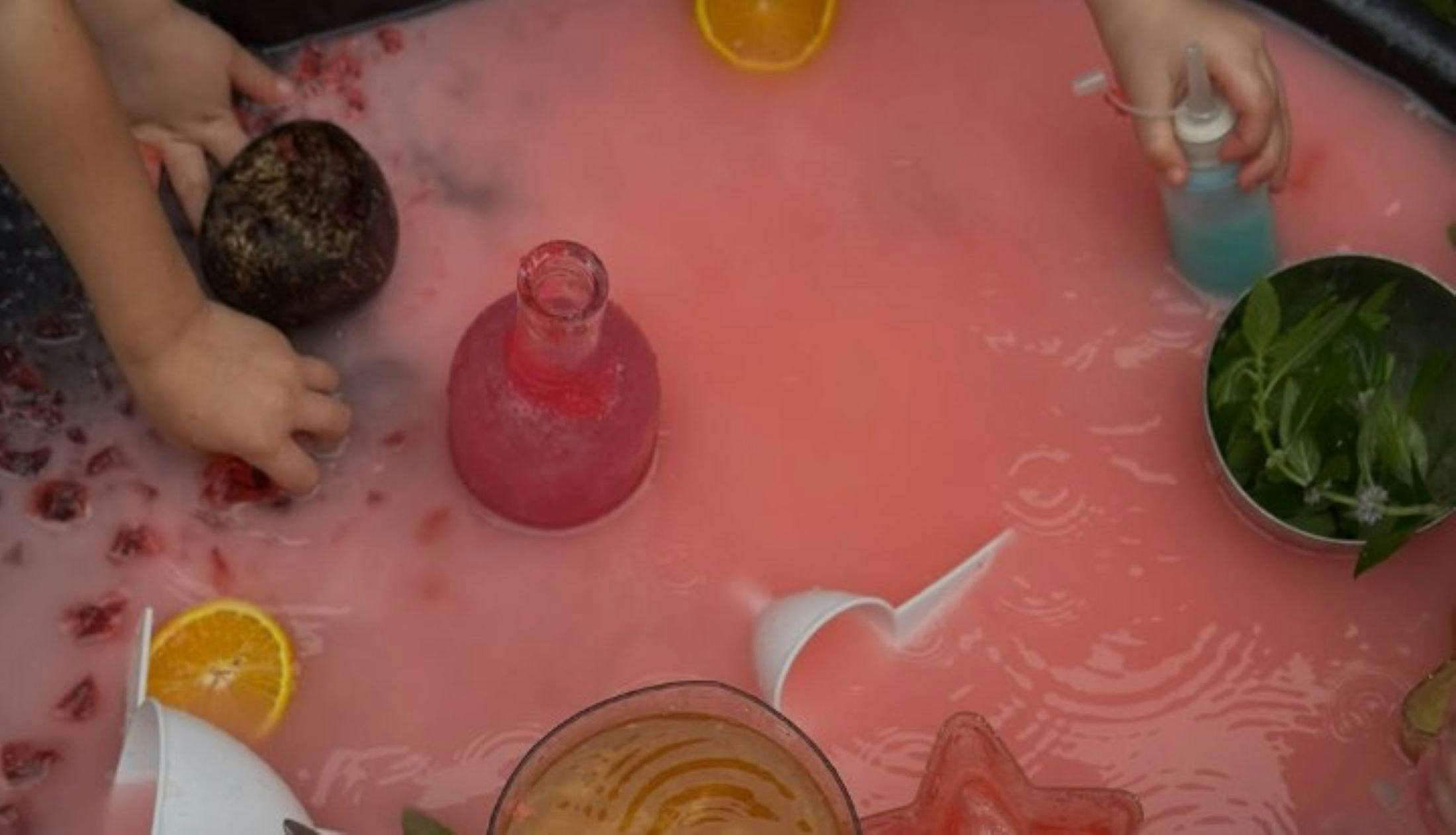 little hands in coloured water scooping up treasures