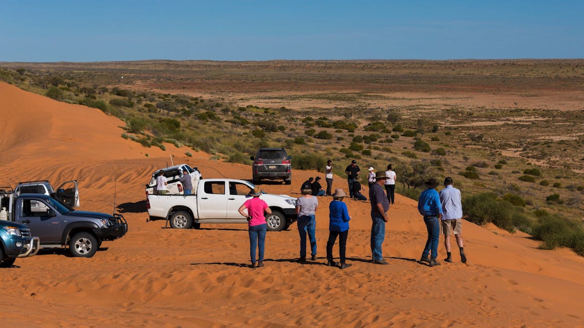 People with their four wheel drives on top of the Big Red Sand Dune near Birdsville