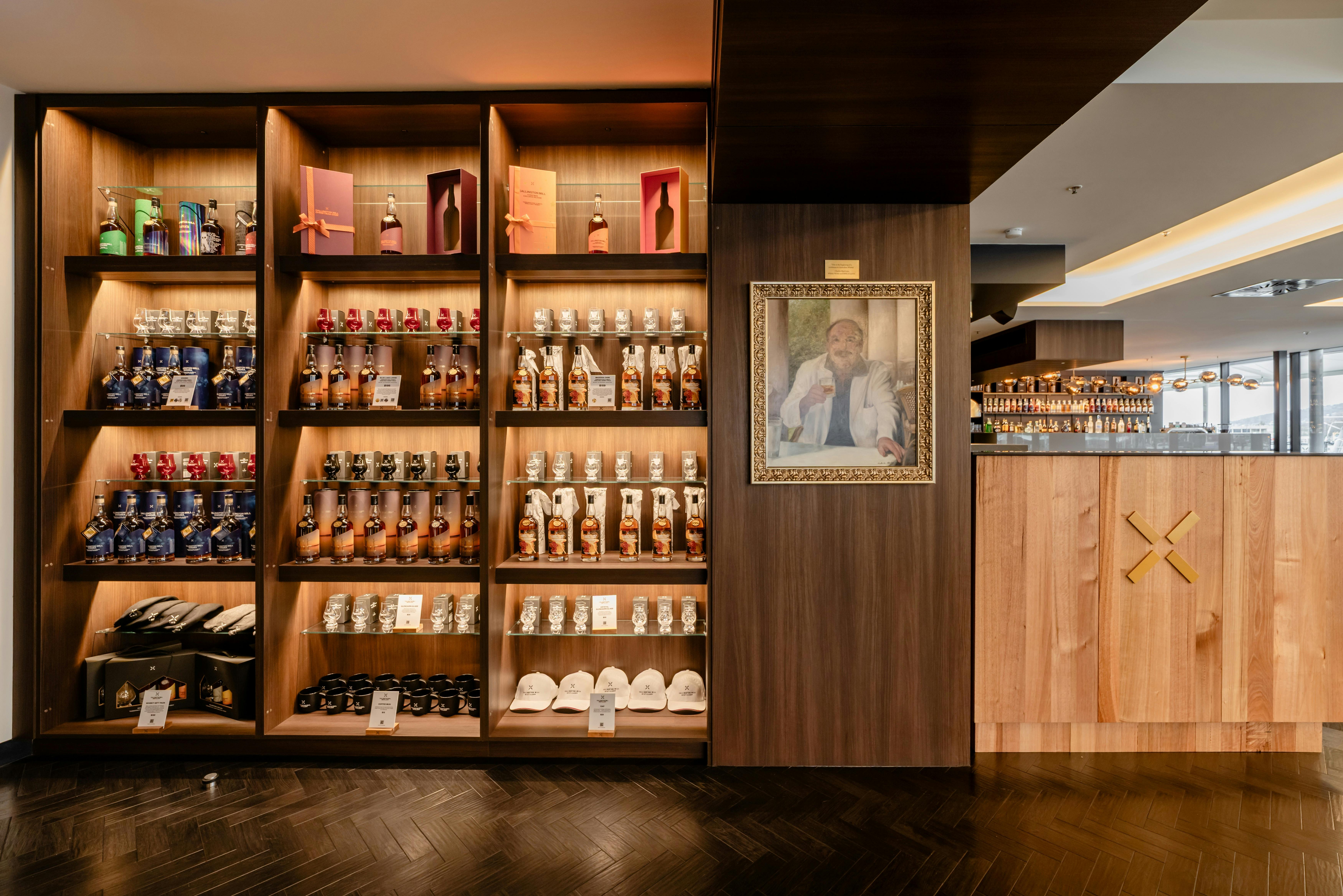 A lit display wall lined with whisky bottles and merchandise