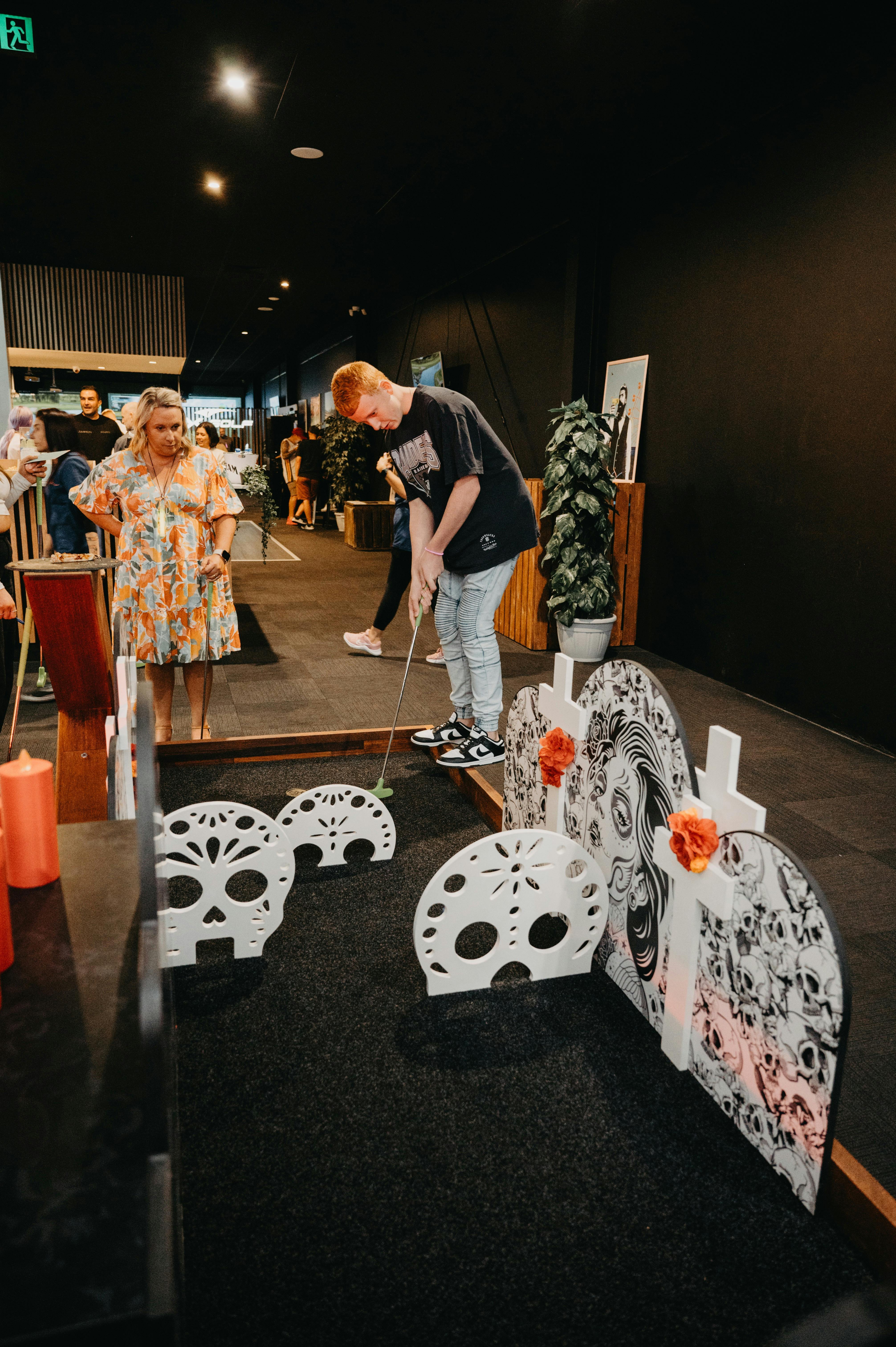 Man and woman playing mini golf at Hey Caddy