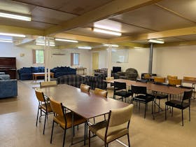 Dining and Recreation Room with 3 big tables with chairs, and couches