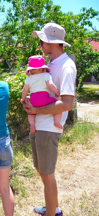 Woman holding device infront of sign with man and two children