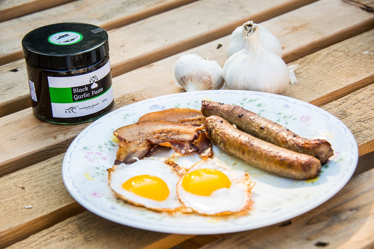 This plate features some cooked duck eggs, beef sausages, nitrate free bacon & black garlic paste.