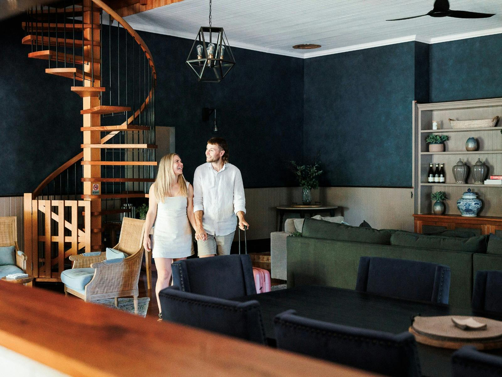 Guests exploring Dal Zotto Homestead living area featuring large couch, spiral staircase
