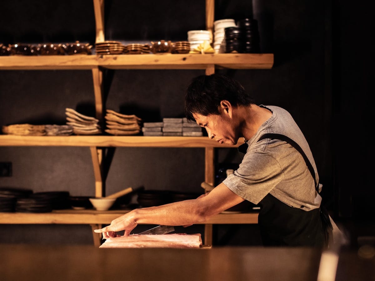 Japanese Chef Koki carving fish in his restaurant Japanese Chef Koki carving fish in his restaurant