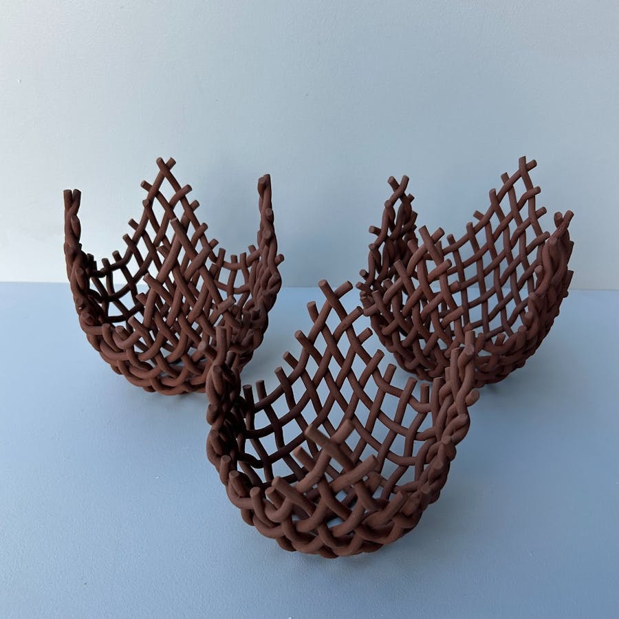 a collection of 3 woven clay baskets