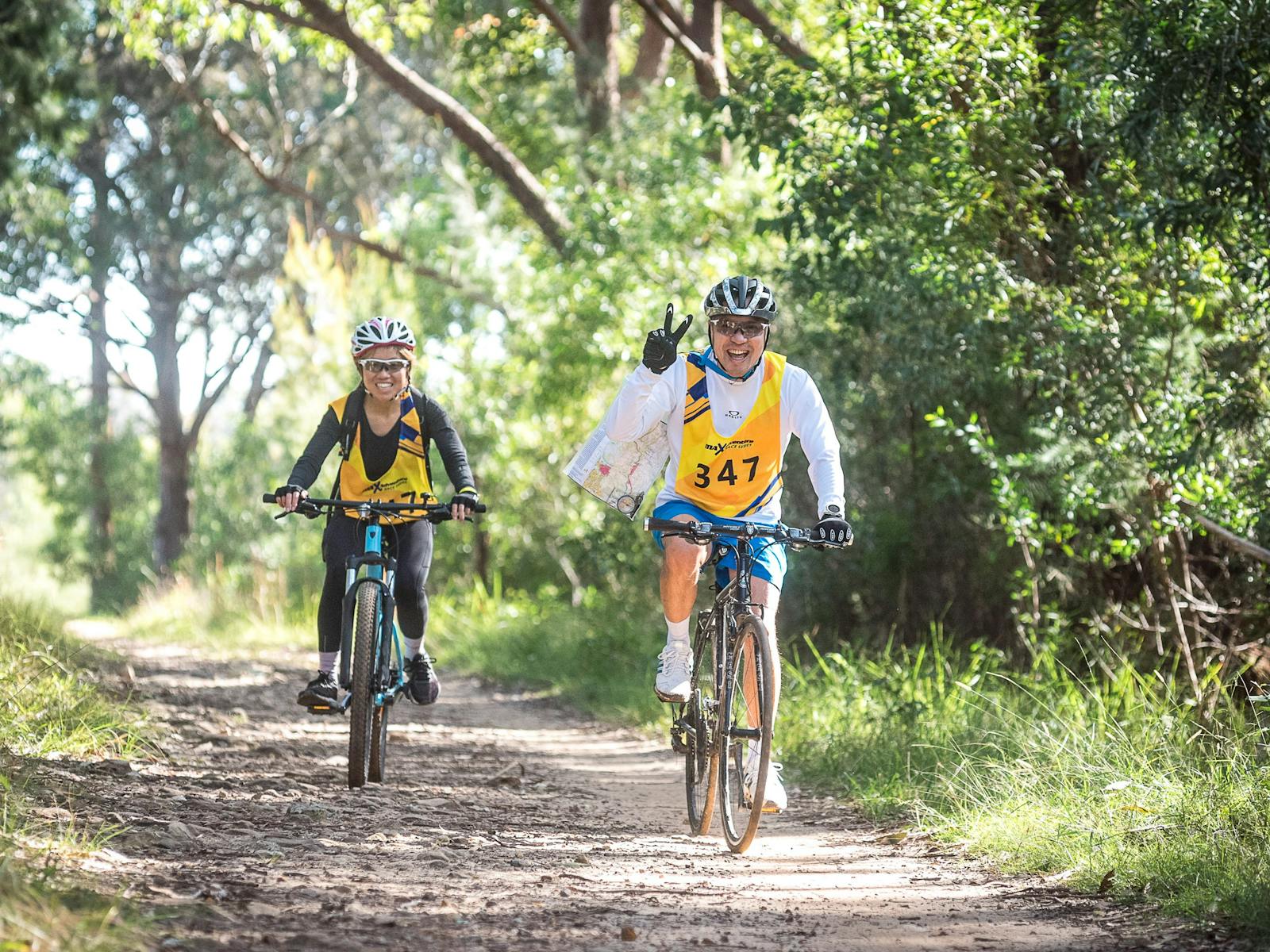 two teammates mountain bike ride together looking for checkpoints