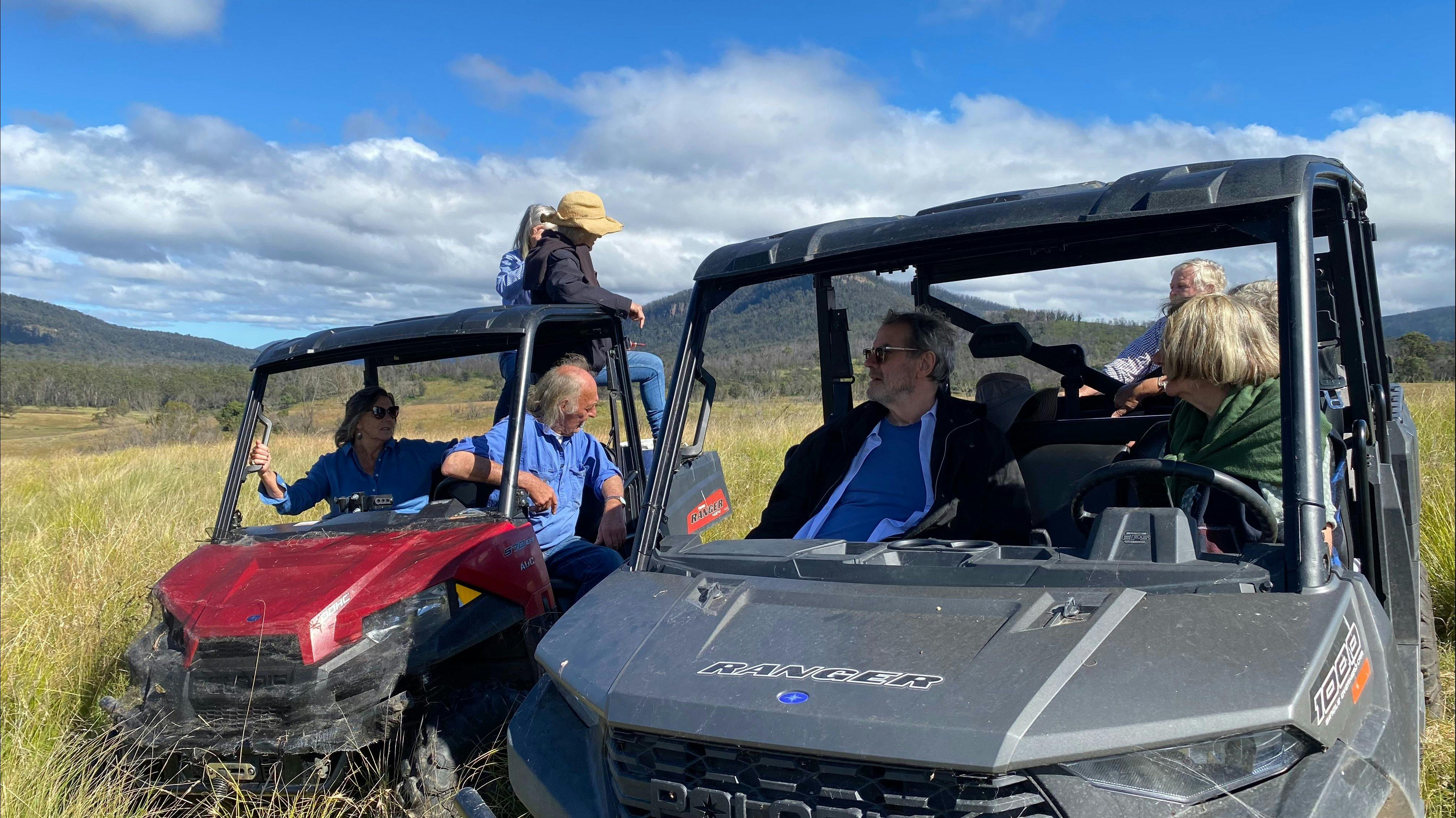 A group of guests all in buggy type vehicles, parked in broad landscape