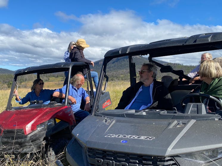 A group of guests all in buggy type vehicles, parked in broad landscape
