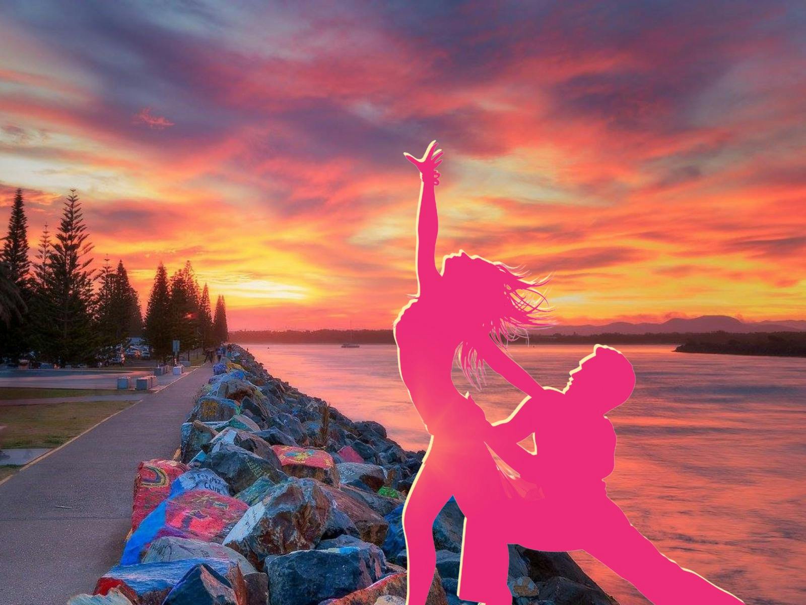 Silohette of Latin dancers in fron to Port Macquarie iconic breakwall