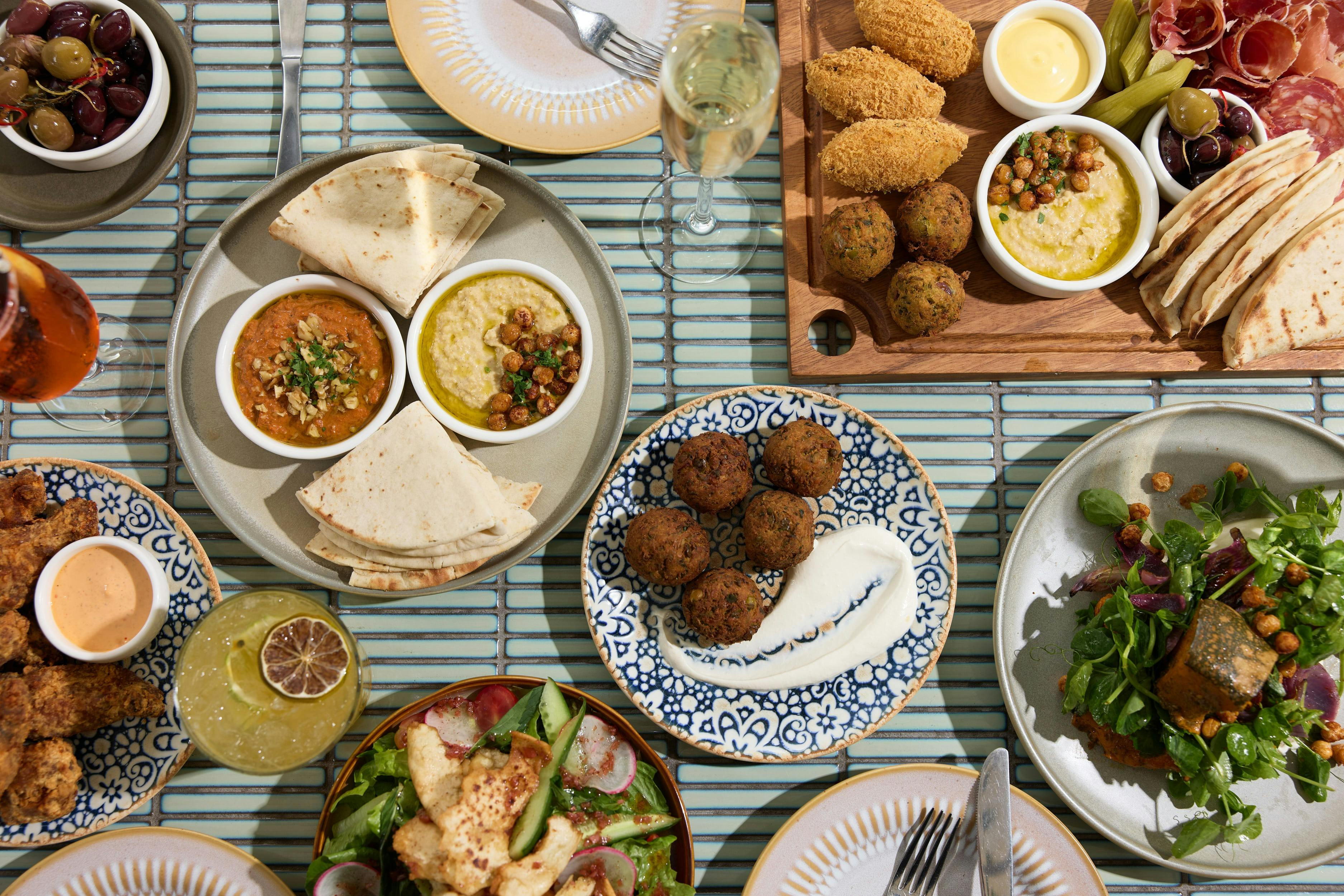 Selection of mezze dishes on a blue tiled tabletop