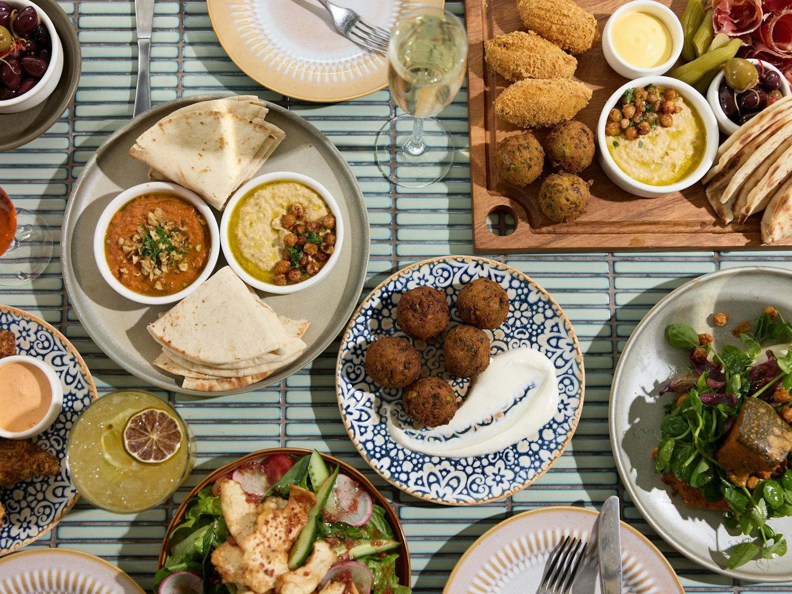 Selection of mezze dishes on a blue tiled tabletop