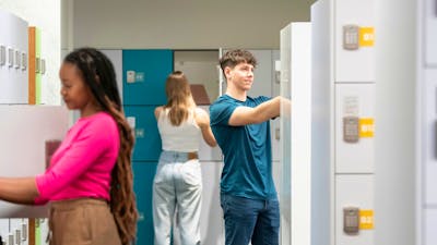 Three students in the locker bay area, storing their personal belongings at the Library.