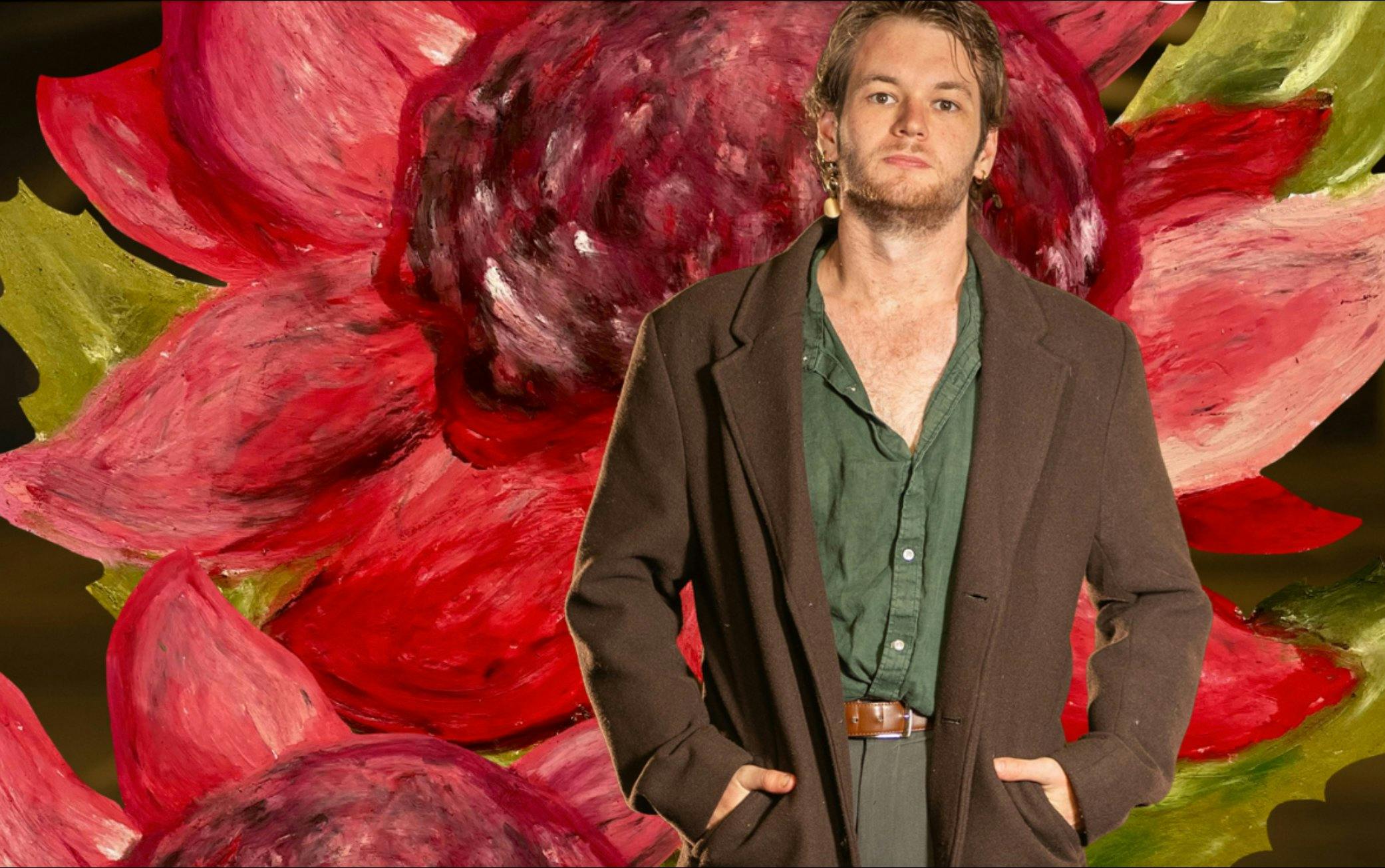 James Shortland stands in  front of large colourful flower painting