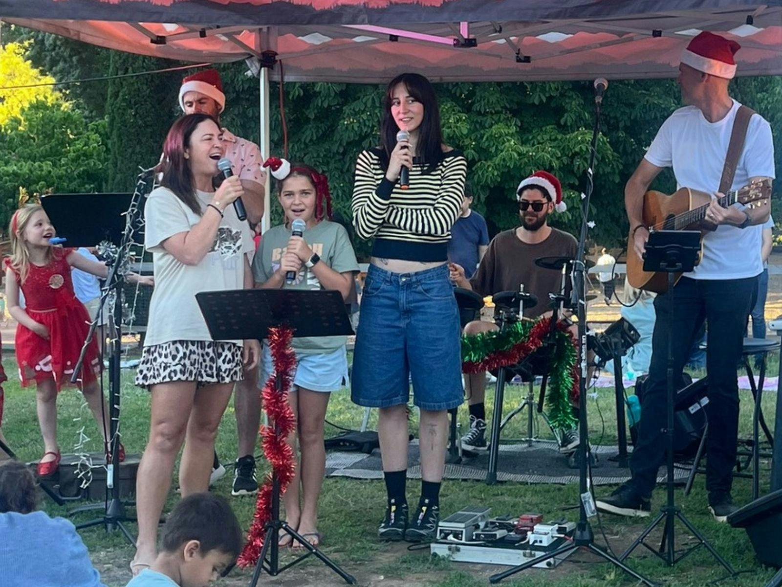 Two female friends singing together at Caroloke in front of a live band.