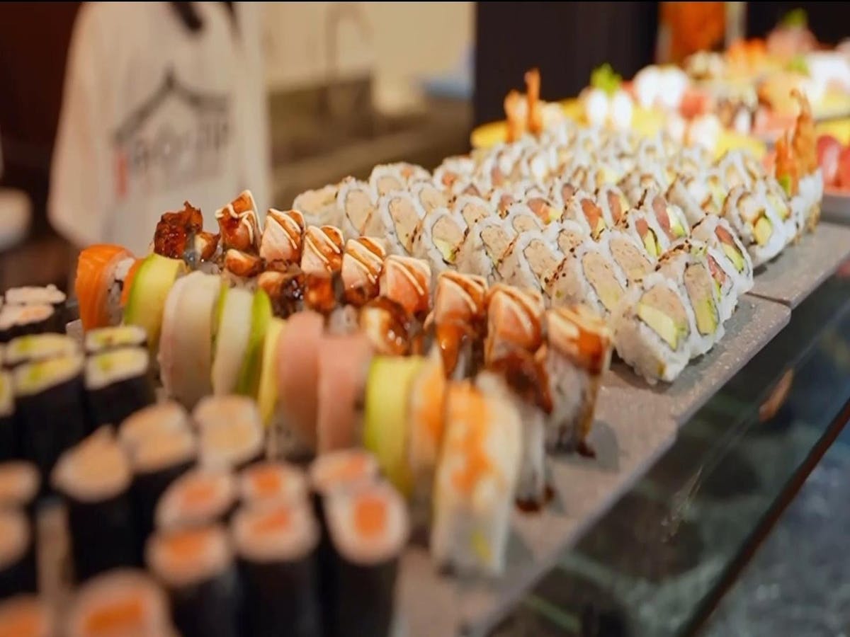 Assorted sushi rolls including salmon, avocado, and grilled eel displayed on a sushi counter