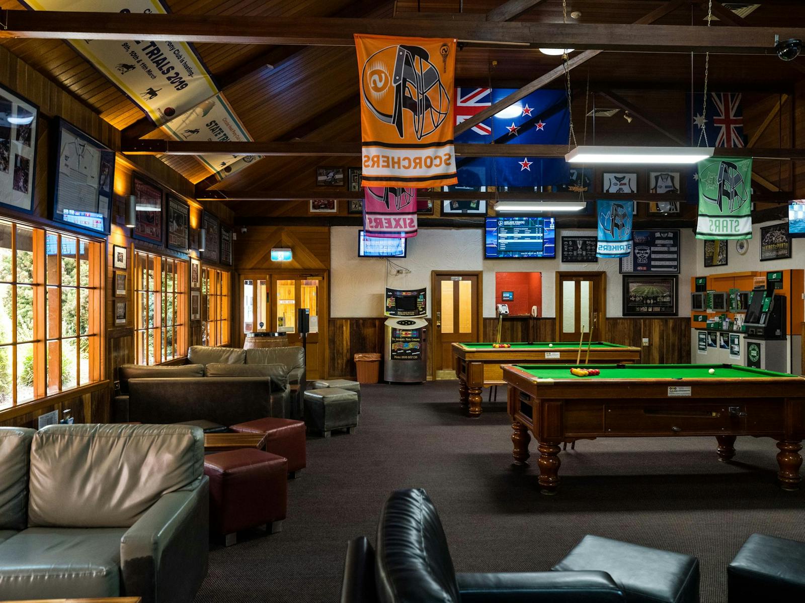 View of Millers Sports Bar with couches, pool tables, juke box and lots of sporting memorabillia