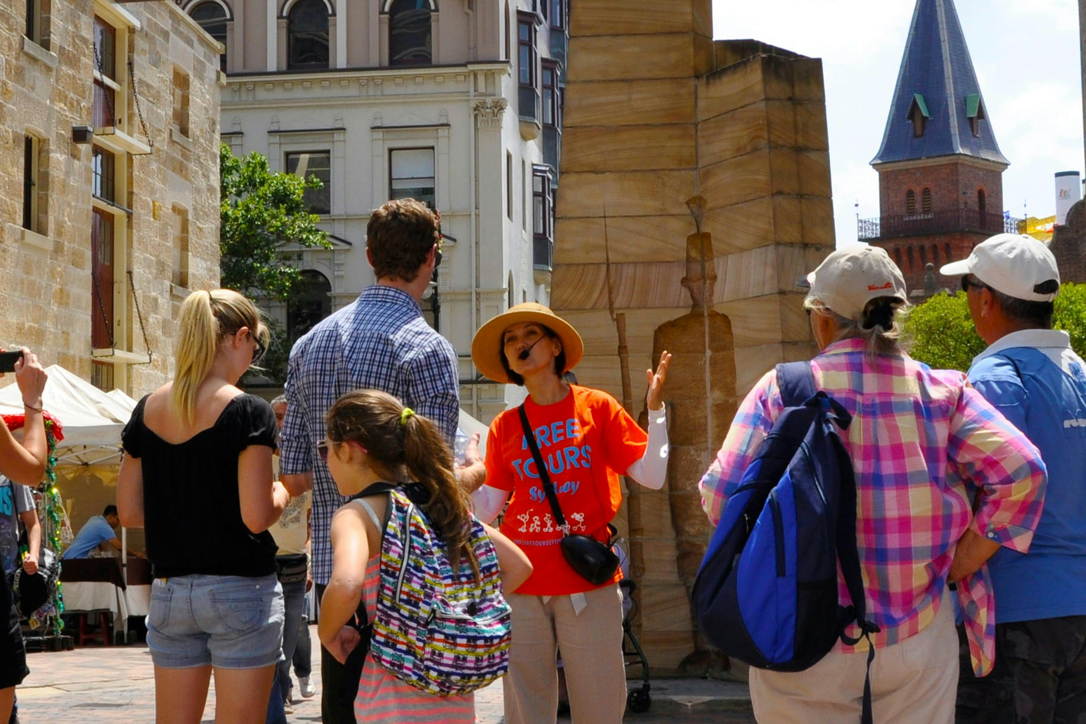 The Rocks free walking tour guide in orange uniform uncovers early history of Sydney