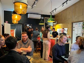 Group of people drinking inside the taproom with bar in background