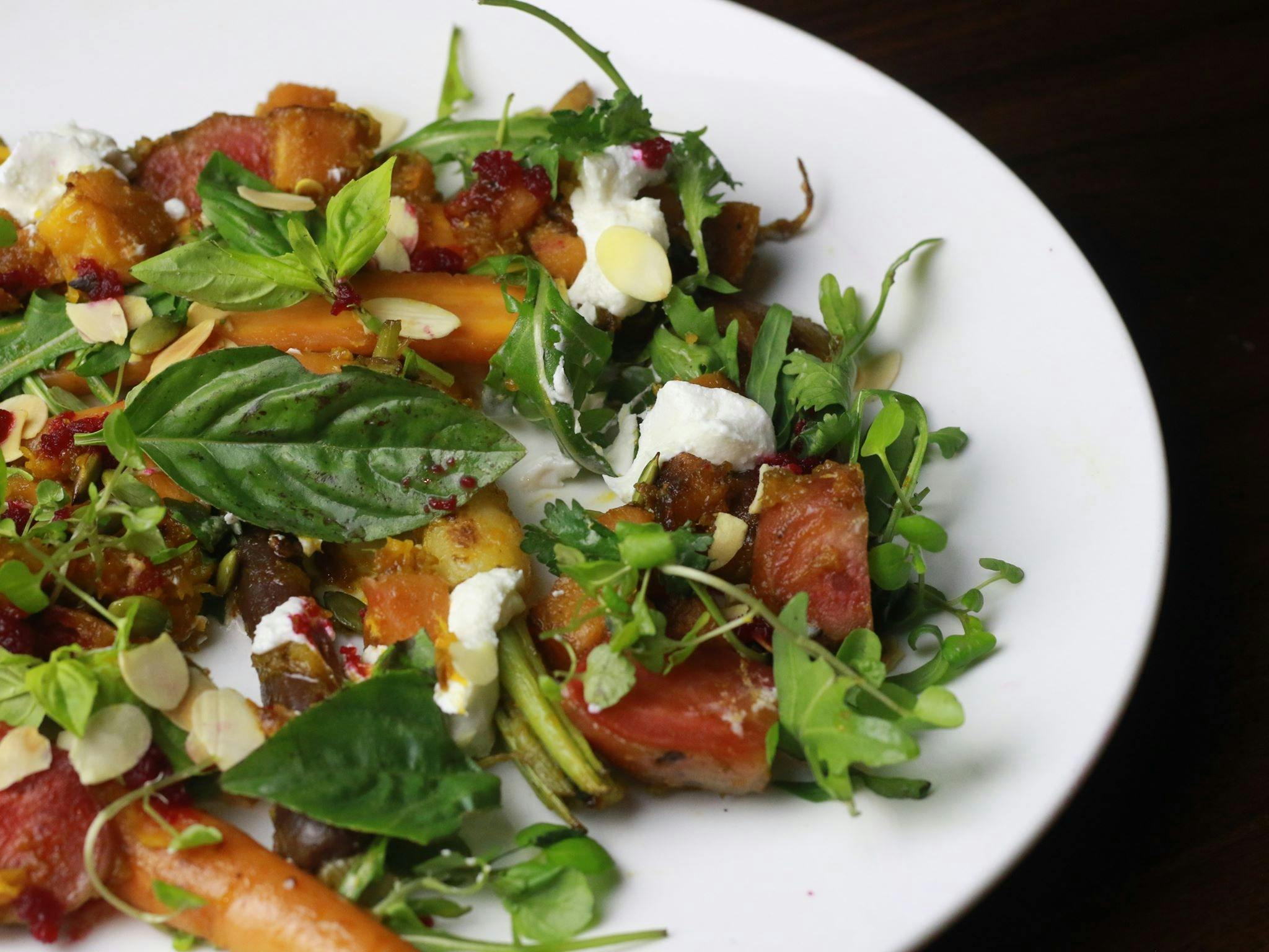 Maple roasted winter vegetables with feta puree & candy nuts, fresh garden herbs and goat cheese.