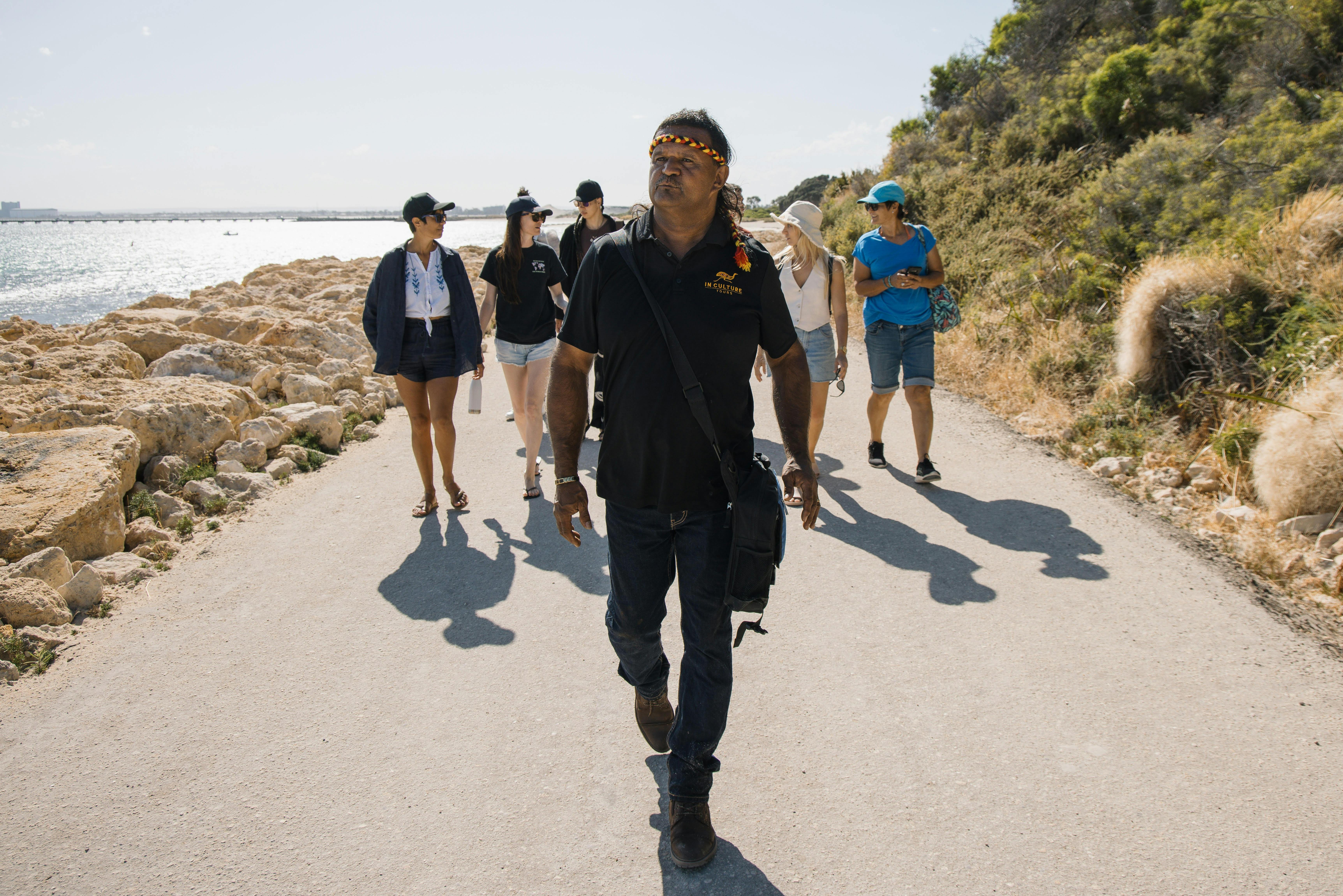 A man is leading a group of people on a cultural tour