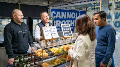 shoppers selecting fresh pasta from local farmers market in Canberra