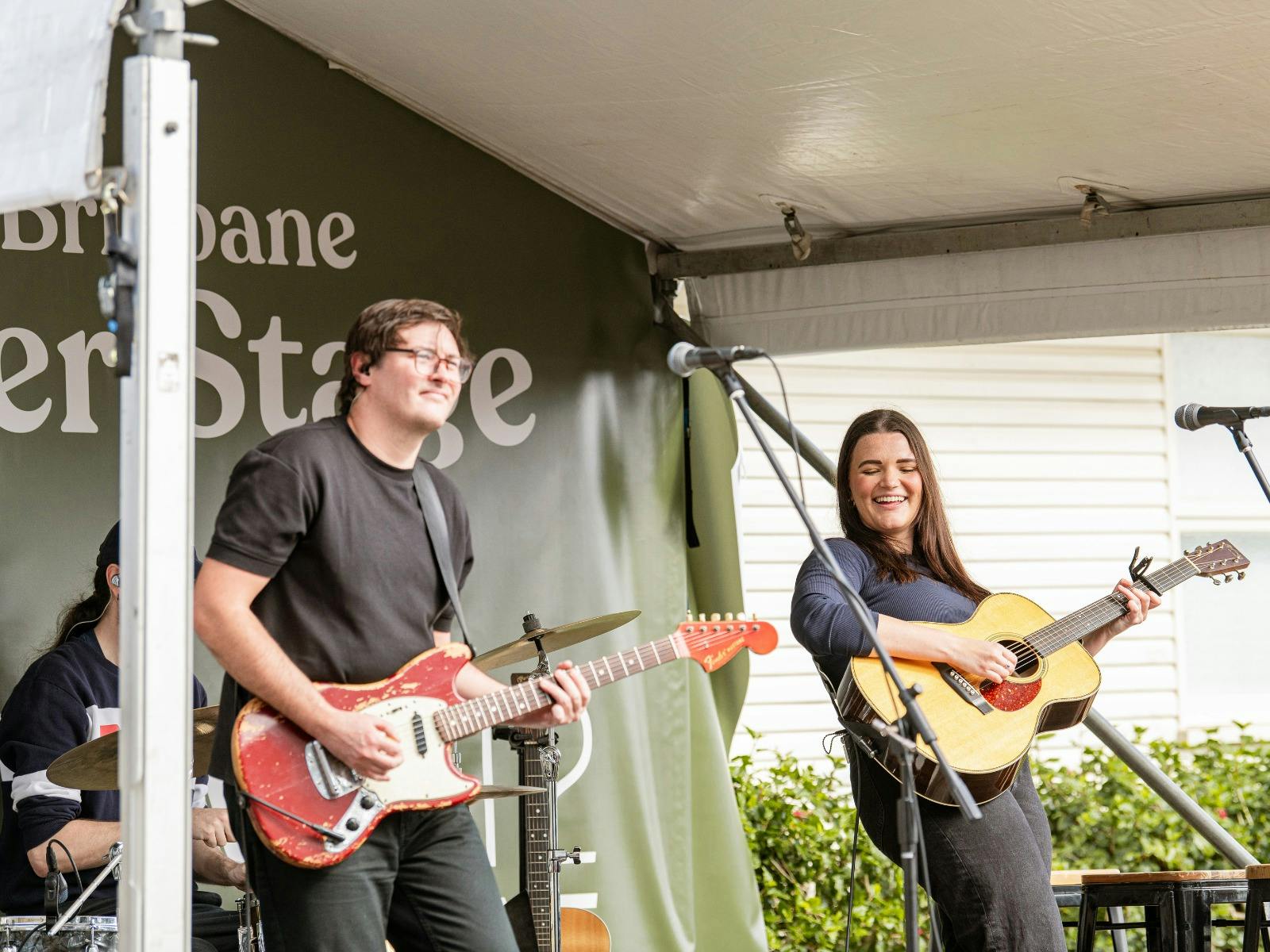 Man and woman from Paper Lane Band playing guitar and performing at the Winter Harvest Festival
