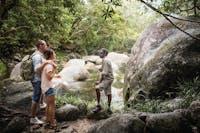 Aboriginal guide at Mossman Gorge, standing by the water with guests.