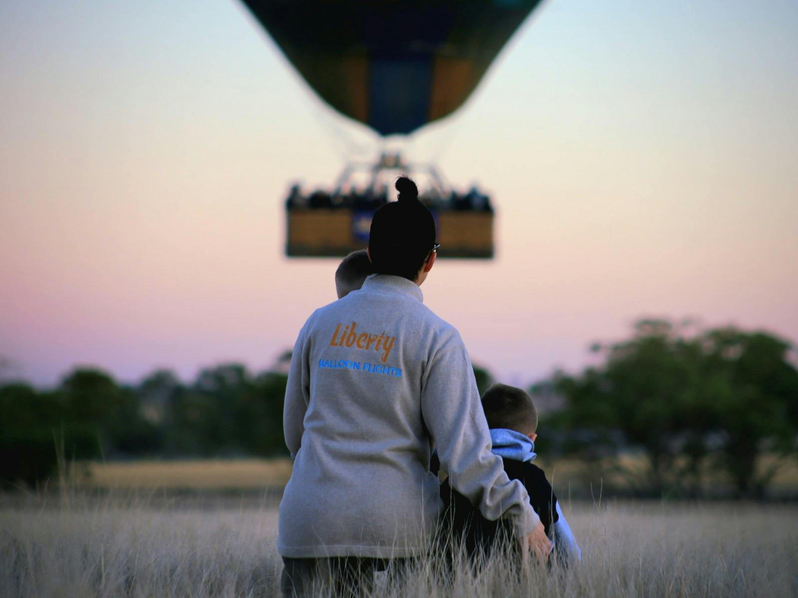 Mother and children watching balloon floating off