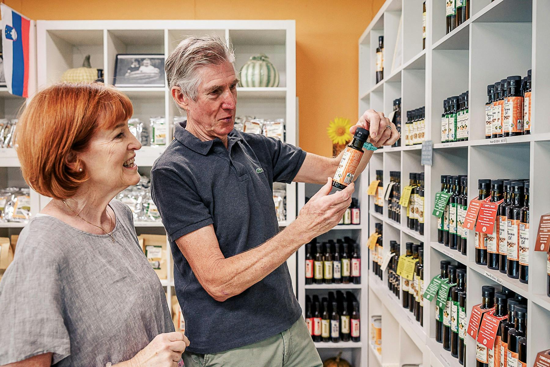 Couple in the Pepo Farms shop holding a bottle of cold pressed oil